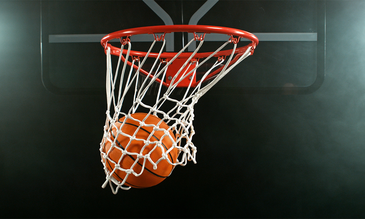 Close-up shot of a basketball in the hoop. Credit: Jag_cz / Shutterstock.