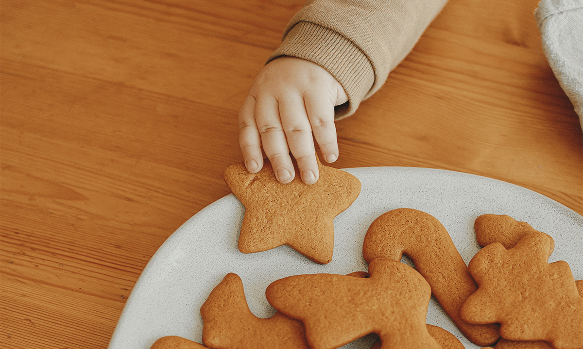 Toddler hand grabbing cookie. Credit: Bogdan Sonjachnyj / Shutterstock.