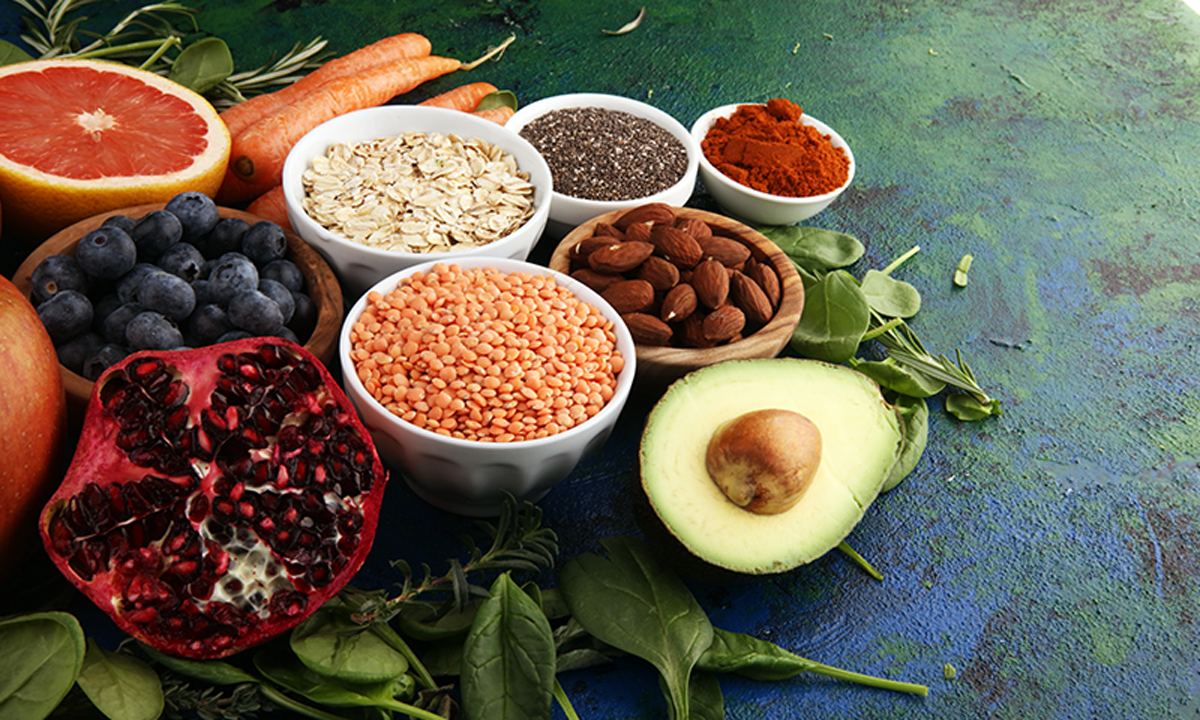 A photo of various "superfoods" including pomegranate and spinach.